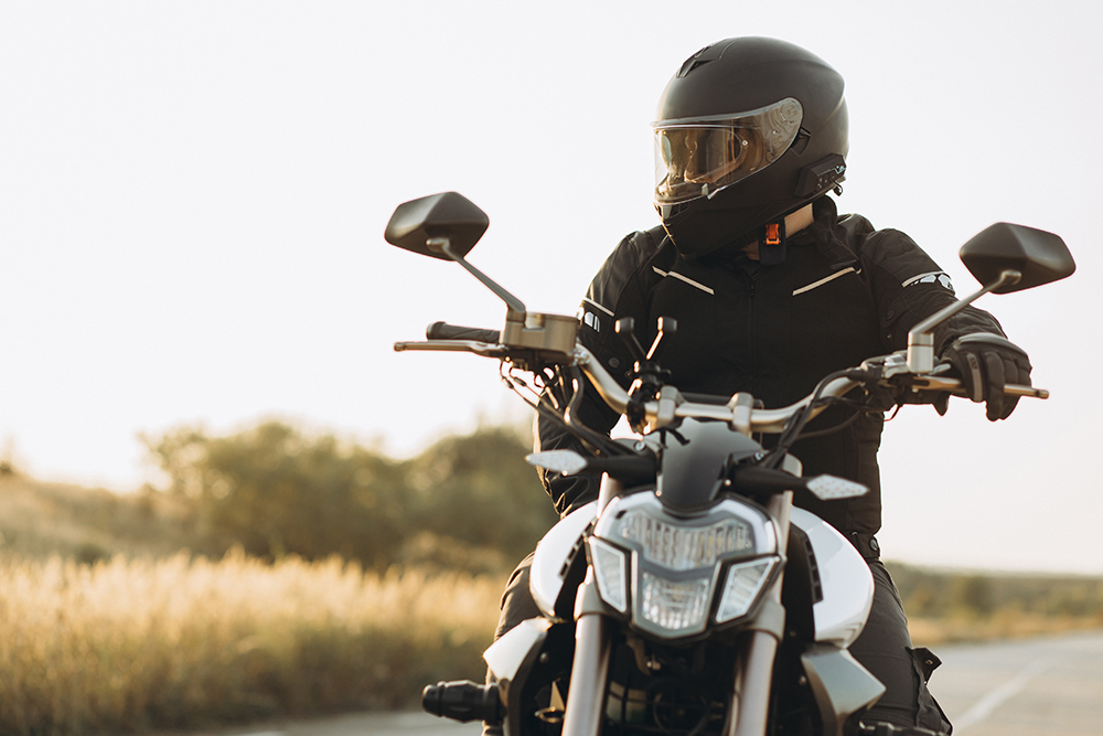 Person riding a motorcycle outside, in a helmet