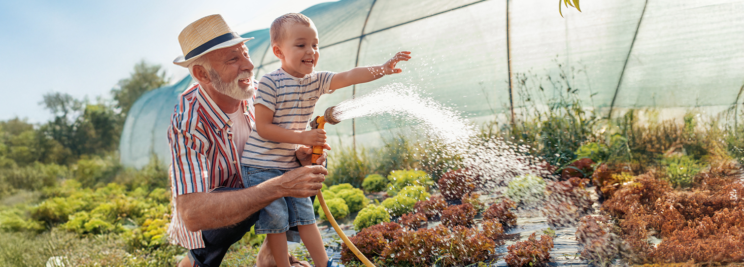 retired grandpa in the garden with his grandchild