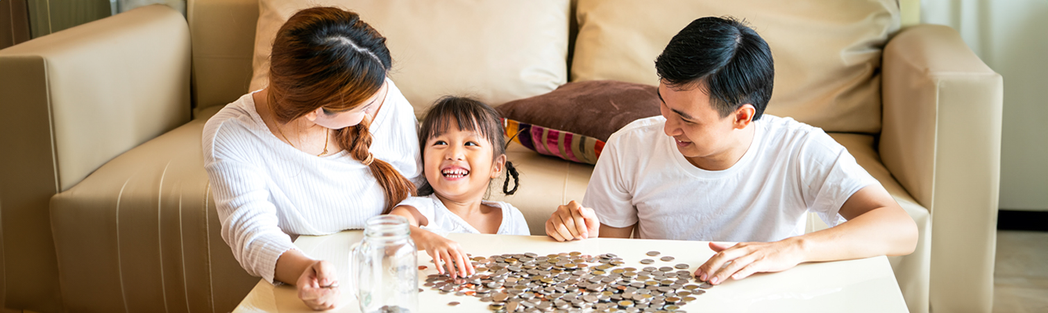 A couple is joined by their young daughter, who is learning about the importance of saving money from them.