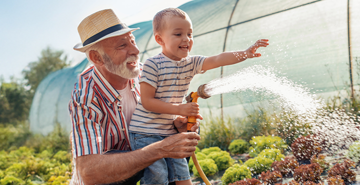 retired grandpa in the garden with his grandchild