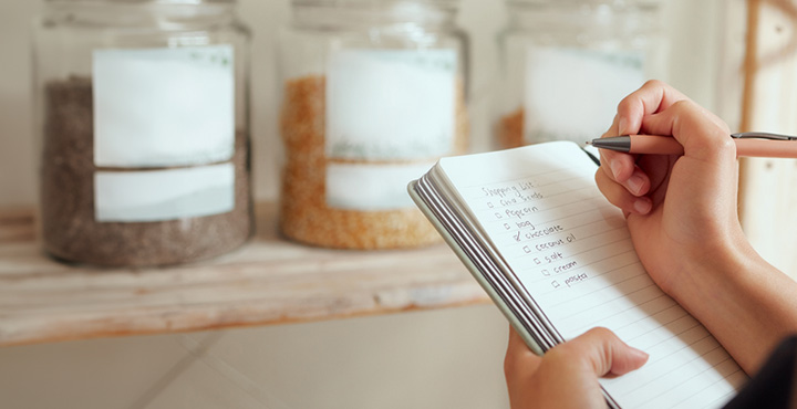 Person writing in notebook to manage personal finances.