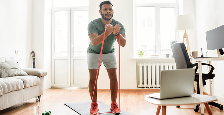 A member is at home doing on exercises in their living room.