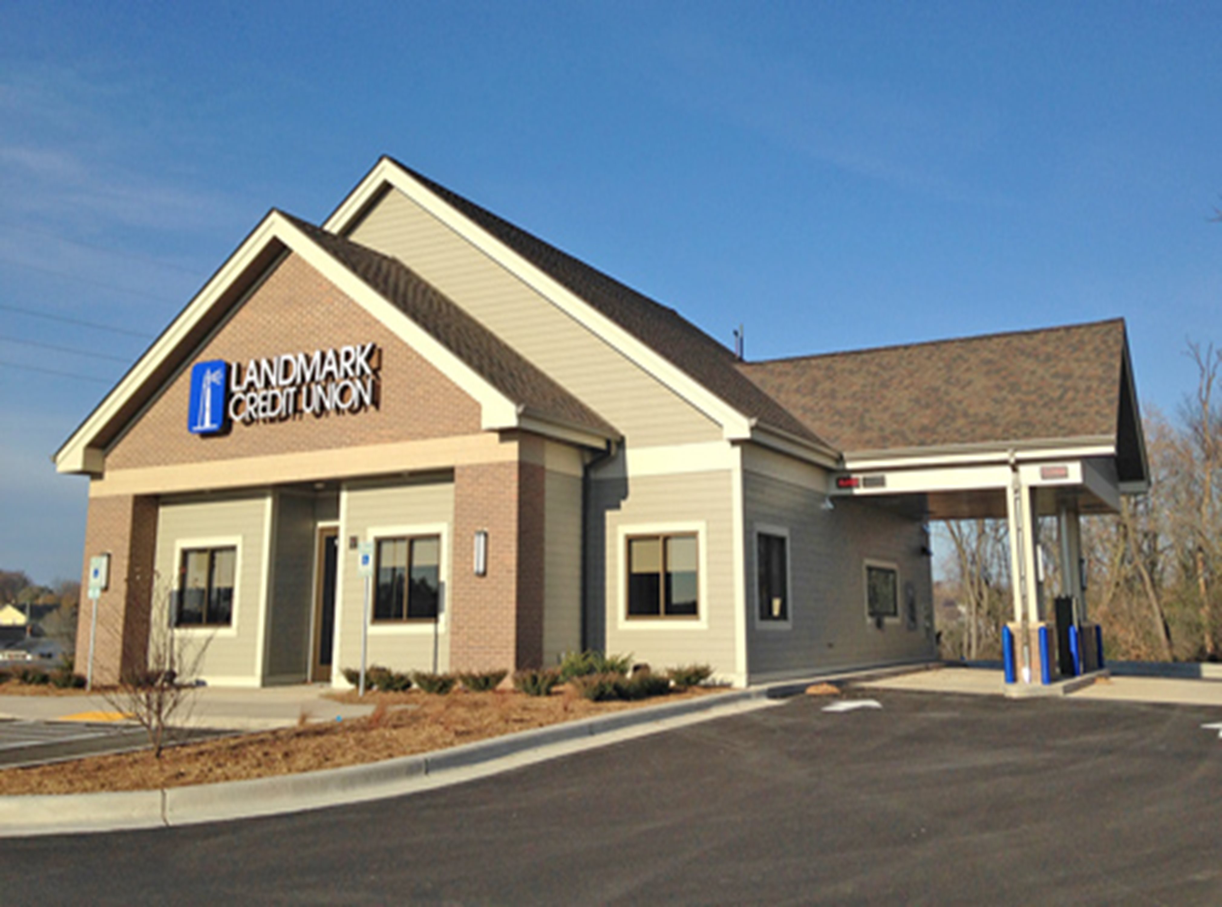 An exterior view of Burlington Branch - brown brick building with parking lot in foreground.