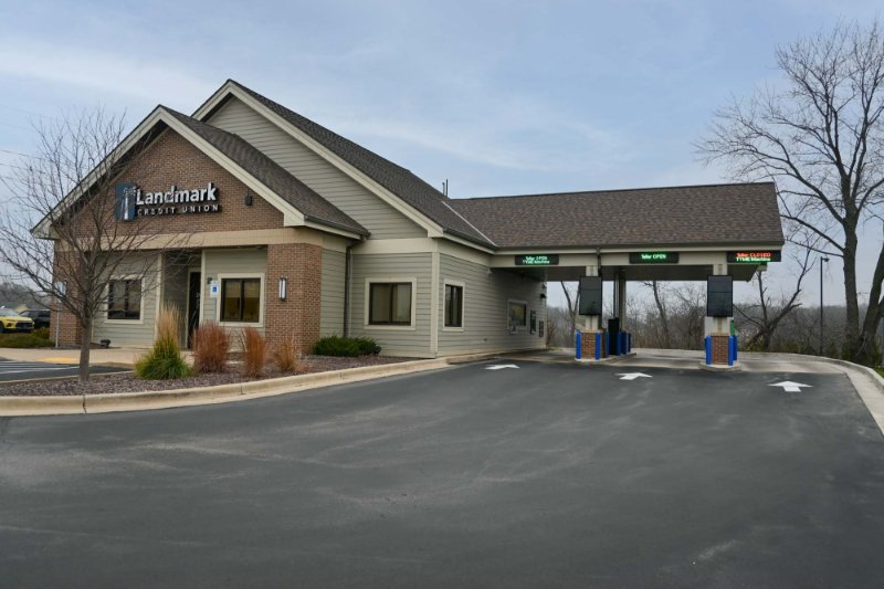 An exterior view of Burlington Branch - brown brick building with parking lot in foreground.