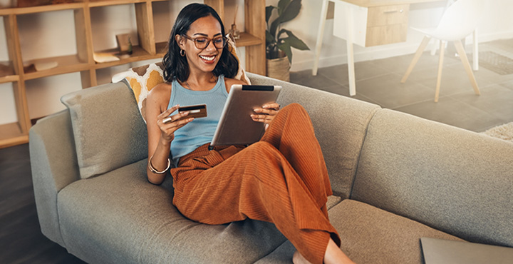 A member is smiling on their couch as they learn about the benefits of Credit Hub.
