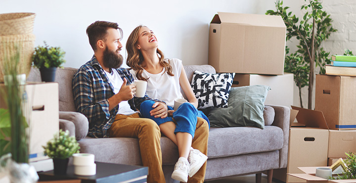 A young couple who have recently moved into their new home are relishing their time together on the couch.