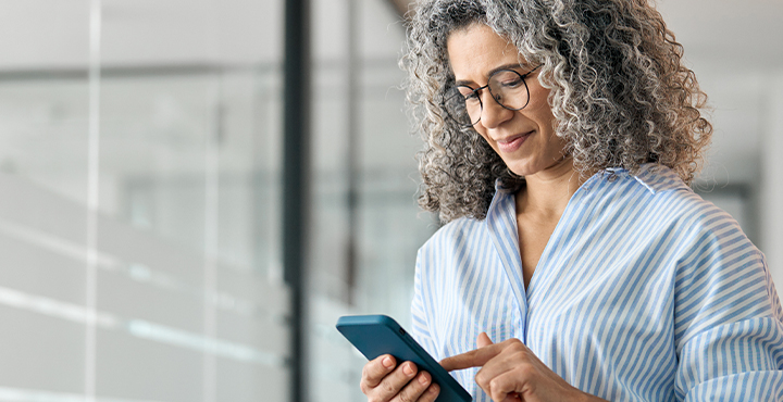 Woman looking at retirement rollover options on her mobile device