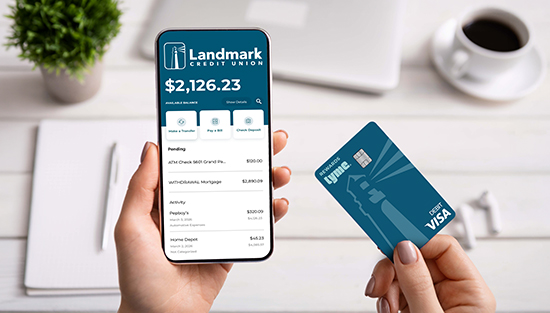 woman checking digital banking and holding a TYME debit card