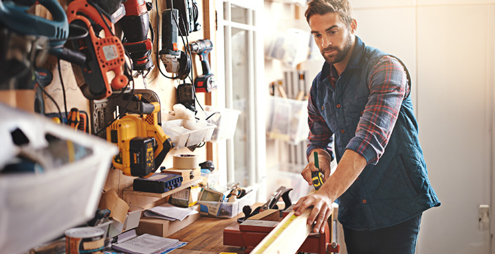 A member is in their workshop at home getting ready trim a piece of wood.