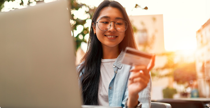  Smiling, a young person checks their credit score online, satisfied with the results.
