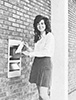 Historical image of a credit union member using an ATM outside the first brick and mortar location that opened in Milwaukee in 1970.