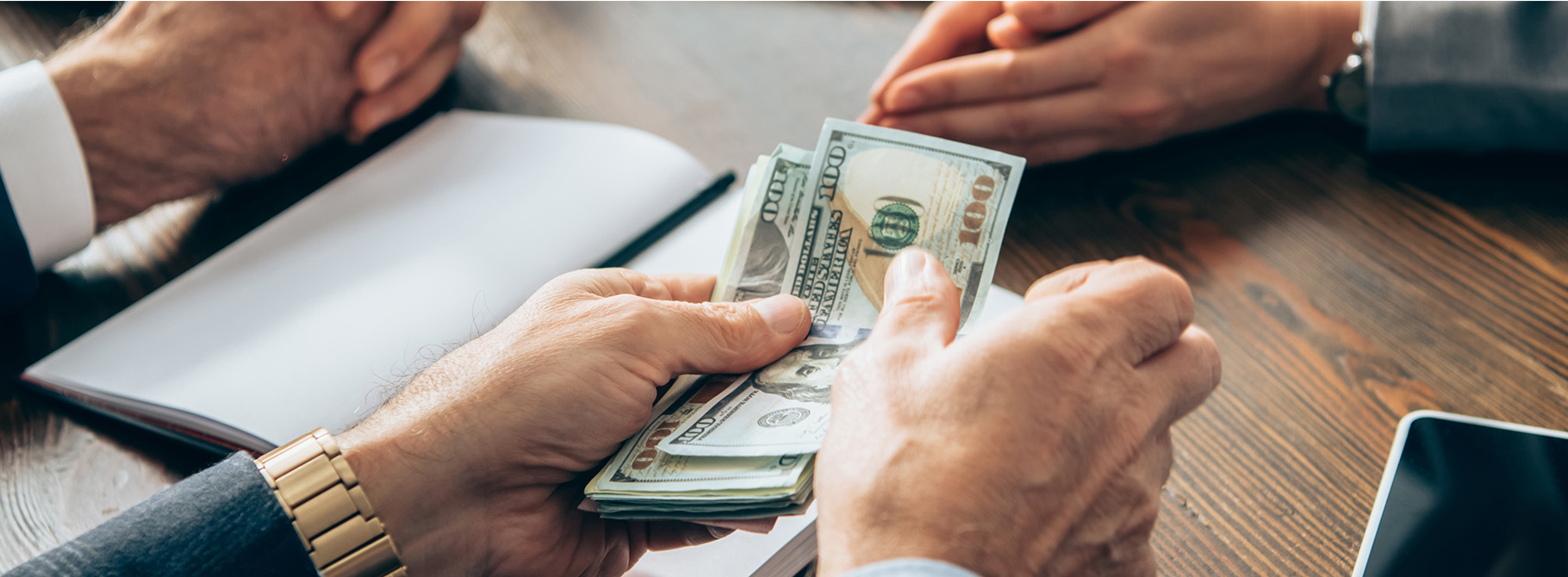 Landmark employee counting cash out on table.